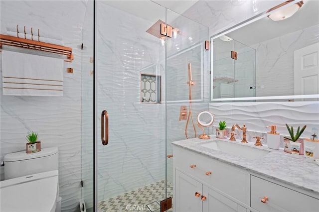 bathroom with vanity, toilet, and a shower with door