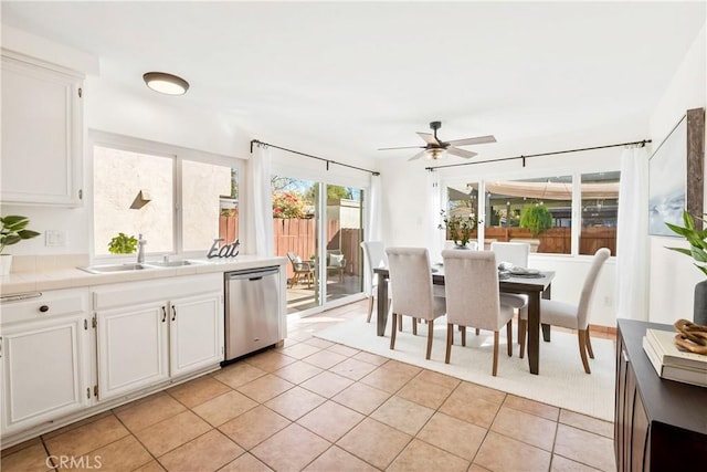 kitchen with light tile patterned floors, dishwasher, sink, and white cabinets