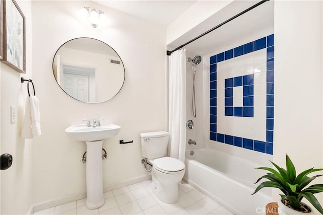 bathroom featuring shower / bath combination with curtain, tile patterned floors, and toilet