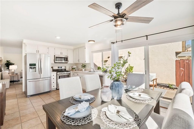 dining space with ceiling fan, sink, and light tile patterned floors