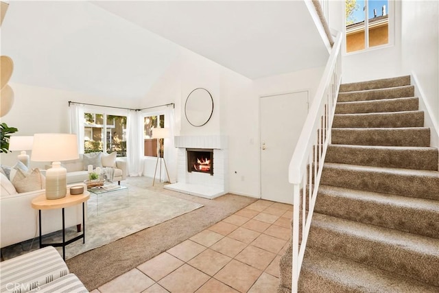 living room featuring tile patterned flooring, a fireplace, and lofted ceiling