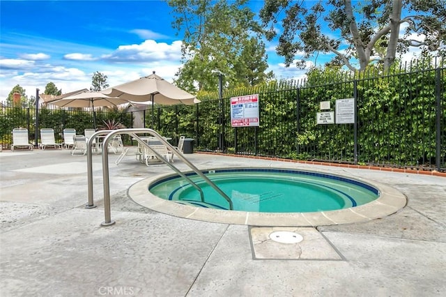 view of swimming pool featuring a hot tub