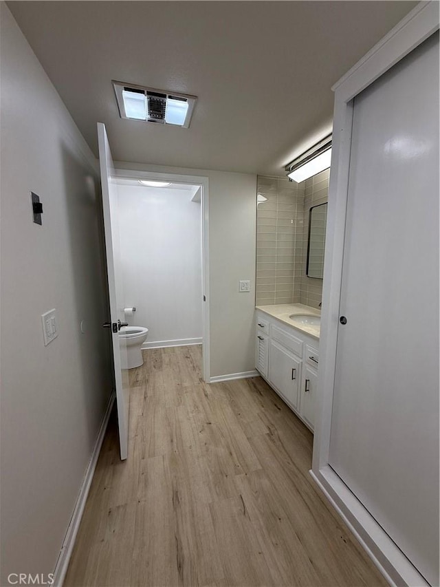 bathroom with vanity, toilet, and wood-type flooring