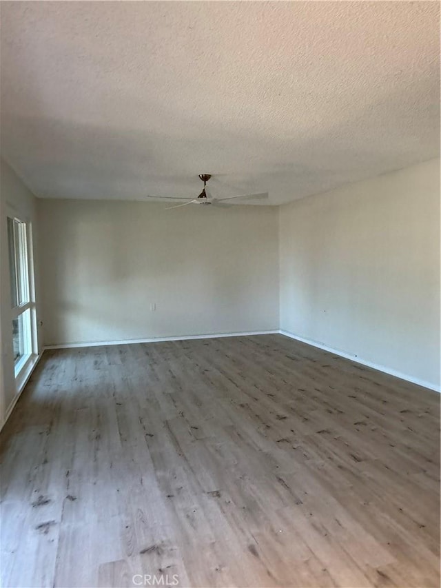 unfurnished room featuring wood-type flooring, a textured ceiling, and ceiling fan