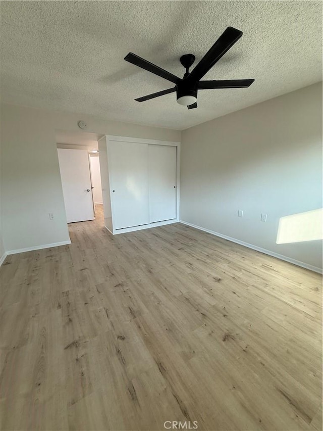 unfurnished bedroom featuring ceiling fan, light hardwood / wood-style flooring, and a textured ceiling