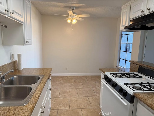 kitchen with a textured ceiling, sink, light tile patterned floors, white range with gas stovetop, and white cabinetry