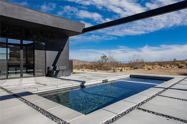 view of swimming pool featuring a mountain view and a patio