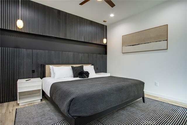 bedroom with ceiling fan and hardwood / wood-style flooring