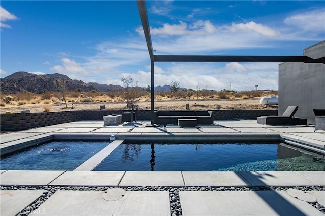 view of pool featuring a jacuzzi, a patio area, and a mountain view