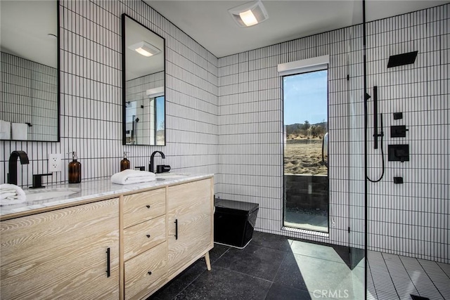 bathroom with tile walls, vanity, tile patterned flooring, and walk in shower