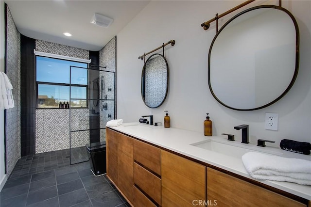 bathroom with tiled shower and vanity