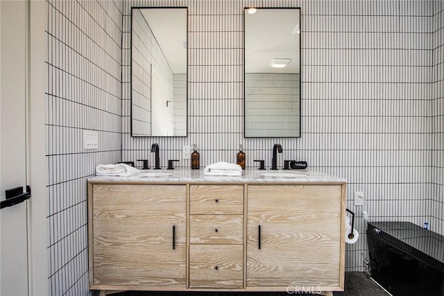 bathroom with vanity and tile walls