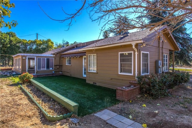 rear view of house with a sunroom and a yard