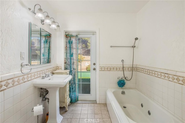 bathroom featuring tile patterned floors, a washtub, tile walls, and sink