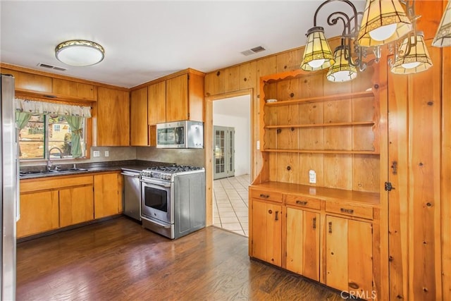 kitchen featuring pendant lighting, dark hardwood / wood-style floors, sink, and appliances with stainless steel finishes