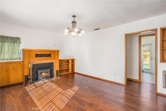 unfurnished living room with dark hardwood / wood-style floors and a notable chandelier