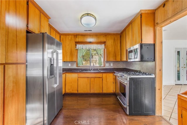 kitchen with backsplash, dark wood-type flooring, french doors, sink, and appliances with stainless steel finishes