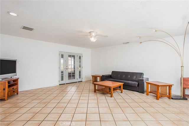 tiled living room featuring ceiling fan and french doors