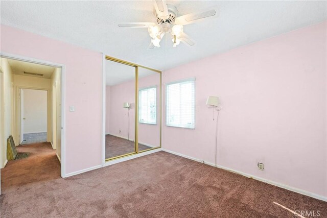 unfurnished bedroom with ceiling fan, a closet, and carpet floors