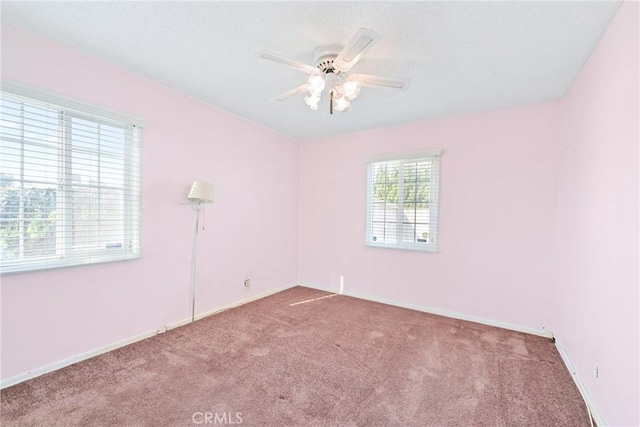 spare room featuring light colored carpet, ceiling fan, and a healthy amount of sunlight