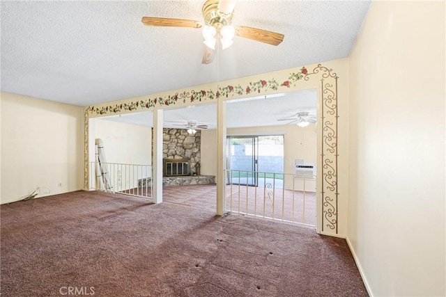 carpeted spare room featuring a fireplace and a textured ceiling