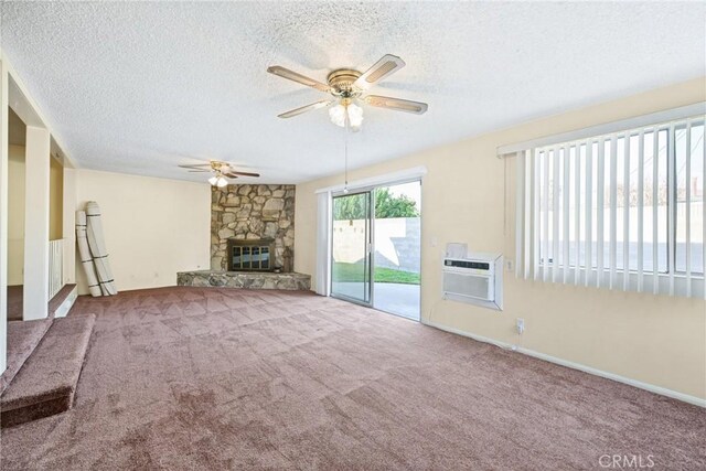 unfurnished living room featuring carpet flooring, ceiling fan, an AC wall unit, a textured ceiling, and a fireplace