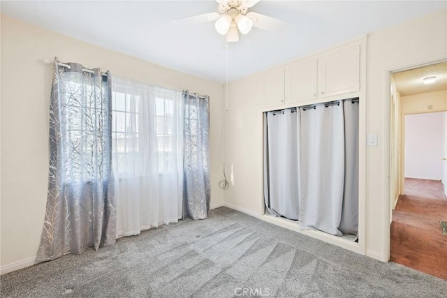 interior space featuring light colored carpet and ceiling fan