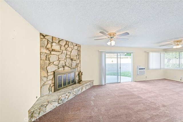 unfurnished living room with carpet flooring, a textured ceiling, a stone fireplace, and ceiling fan