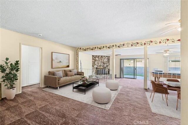 carpeted living room featuring a fireplace and a textured ceiling