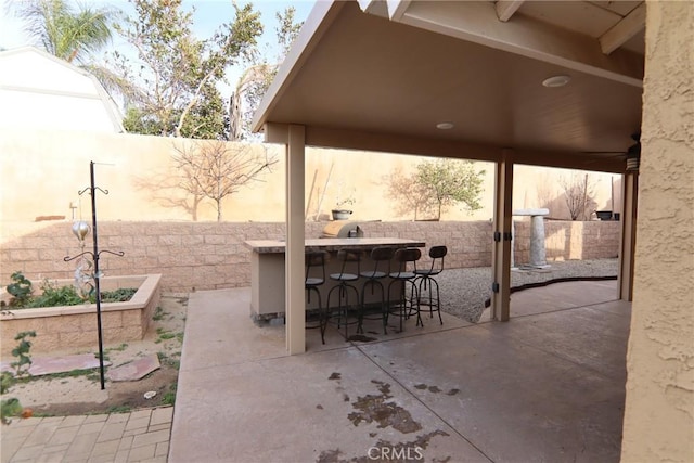 view of patio with a fenced backyard and outdoor dry bar