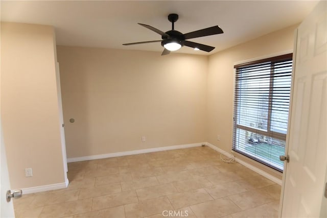 empty room featuring a ceiling fan and baseboards