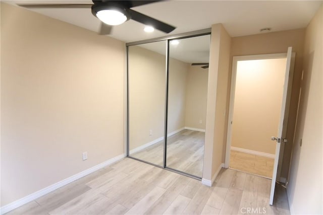 unfurnished bedroom with a ceiling fan, a closet, baseboards, and light wood finished floors