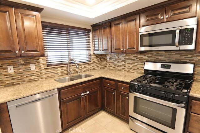 kitchen with appliances with stainless steel finishes, decorative backsplash, and a sink