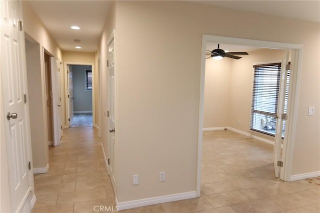 hall with recessed lighting, light tile patterned flooring, and baseboards