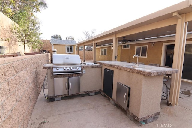 view of patio with grilling area, a ceiling fan, a sink, exterior kitchen, and outdoor wet bar