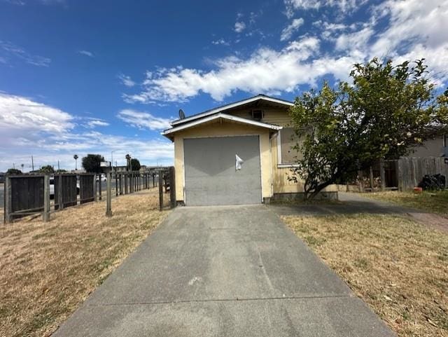 view of side of property featuring a garage and a lawn