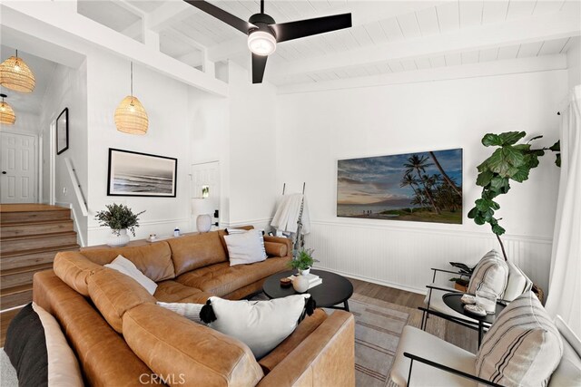 living room with ceiling fan, beam ceiling, wood-type flooring, and wood ceiling