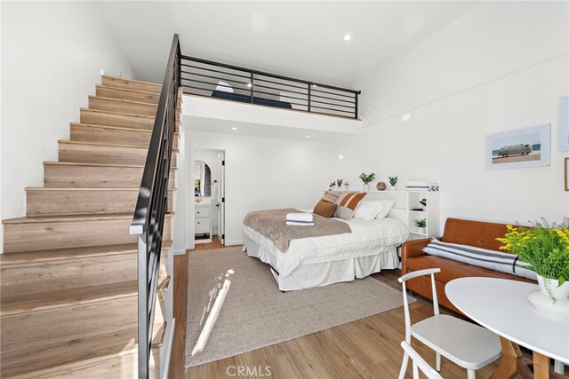 bedroom with wood-type flooring and a high ceiling