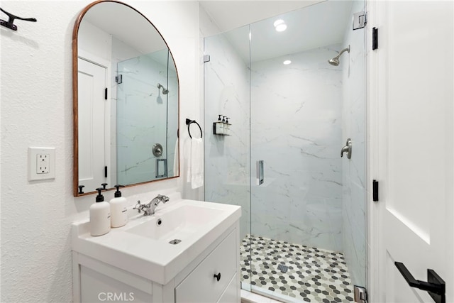 bathroom featuring vanity and a shower with door