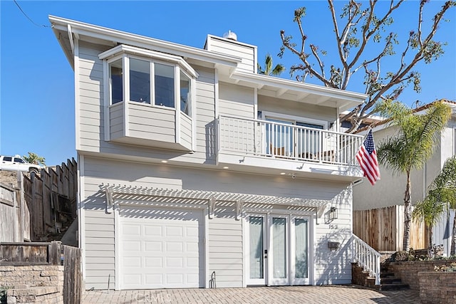 back of property featuring a balcony and a garage