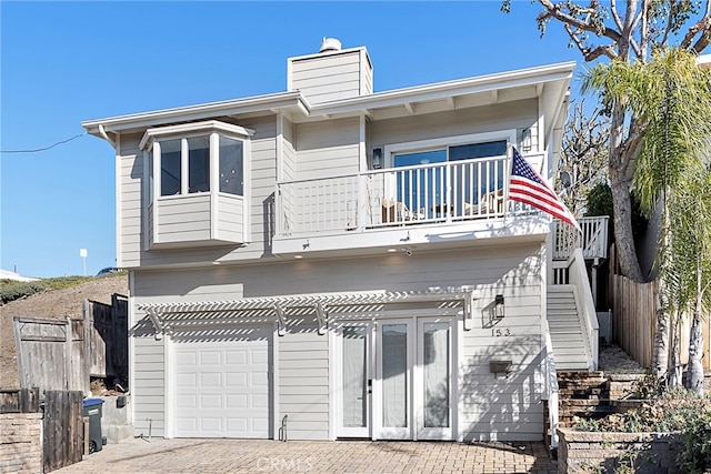 back of house with french doors and a balcony