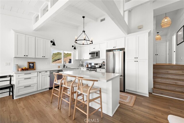 kitchen with pendant lighting, appliances with stainless steel finishes, and white cabinets