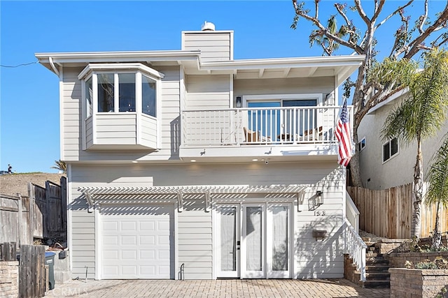 view of front of home with a garage and a balcony