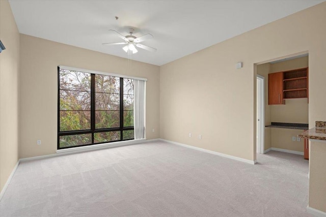 spare room featuring ceiling fan and light colored carpet