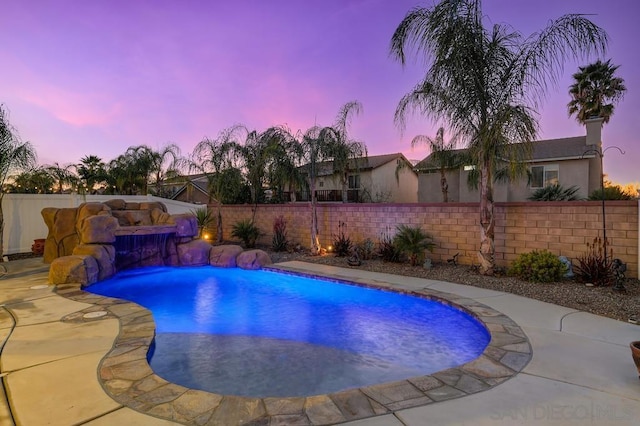 pool at dusk with a patio area