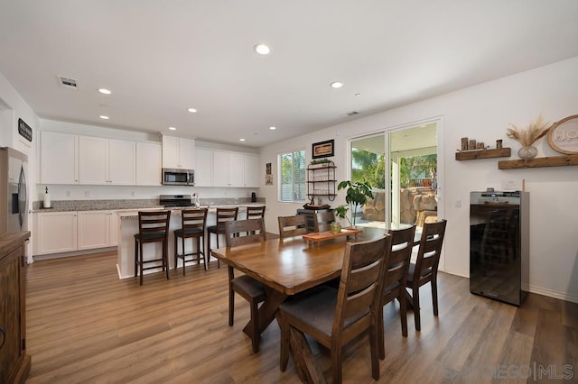 dining space featuring hardwood / wood-style flooring and wine cooler