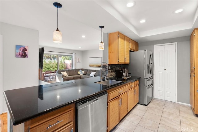 kitchen featuring pendant lighting, sink, tasteful backsplash, kitchen peninsula, and stainless steel appliances