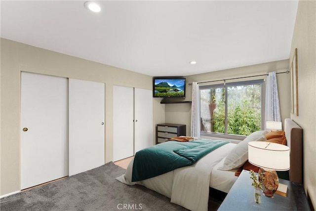 bedroom with carpet floors and two closets