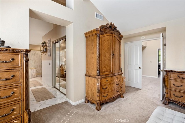 bedroom featuring light carpet, a closet, and vaulted ceiling