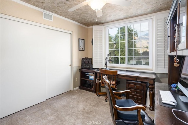 office space with light carpet, ceiling fan, crown molding, and a textured ceiling